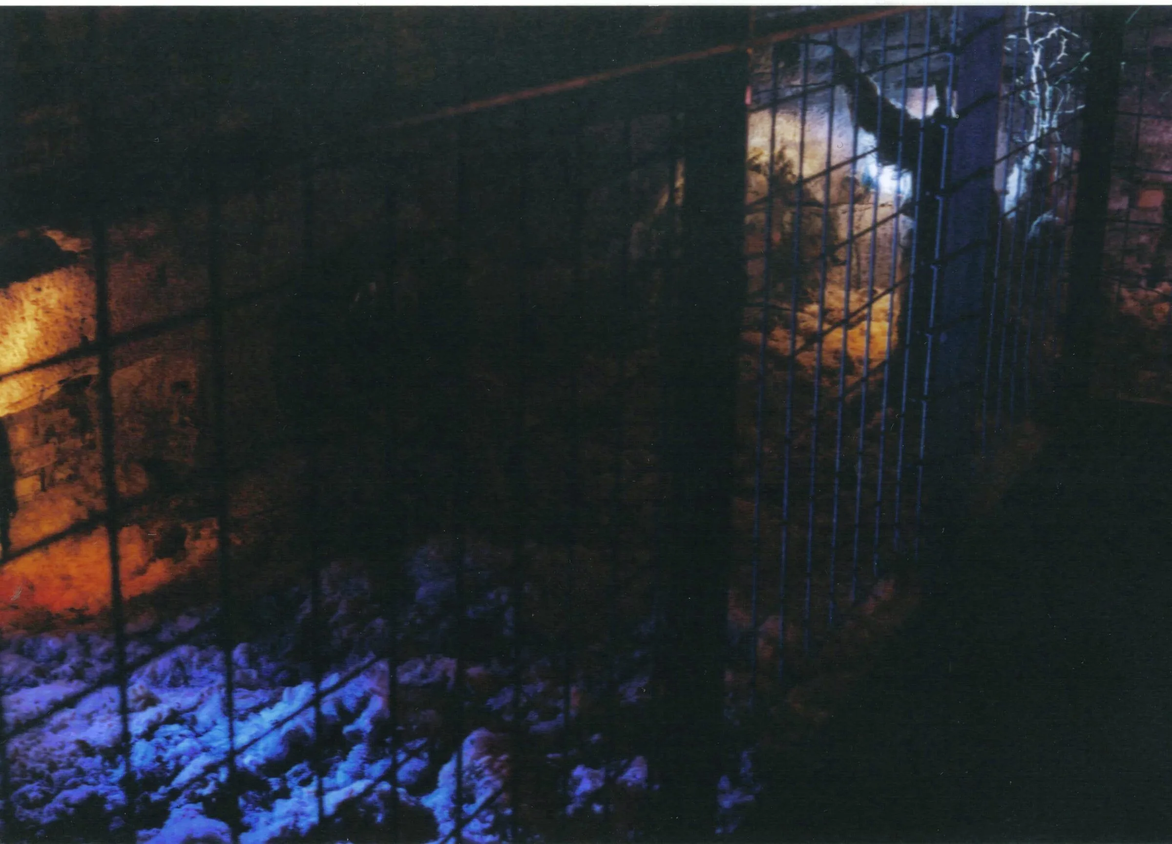 Innenraum — schwebender Käfig zwischen Mauerwerk und blauem Licht